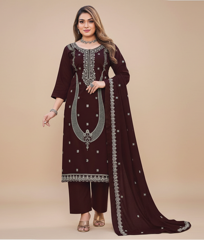 Woman wearing a maroon embroidered traditional outfit on a beige background